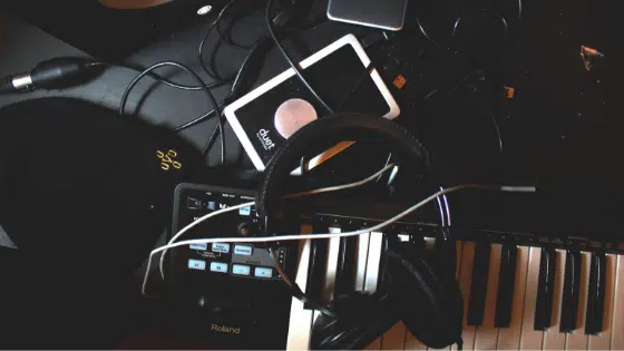 A black keyboard with headphones and a cell phone.