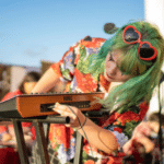 A woman with green hair playing a keyboard.