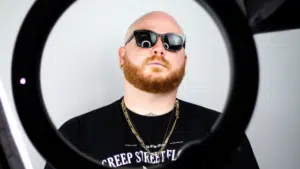 A man with a red beard and sunglasses in front of a mirror.