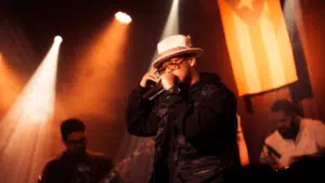 A man in a hat singing into a microphone.