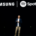 A man standing in front of a samsung spotify logo.