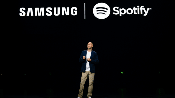 A man standing in front of a samsung spotify logo.