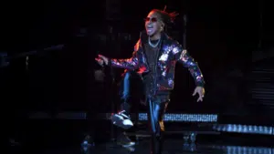 A man in a leather jacket is performing on stage.