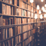 A row of books in a library with light bulbs.