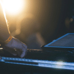 A person playing a keyboard in front of a light.