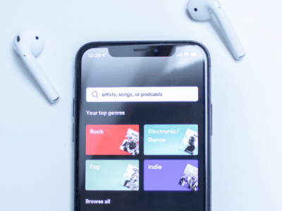 An iphone with earphones next to it.