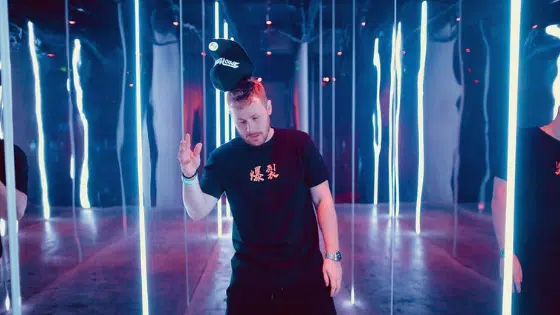 A group of people standing in a room with neon lights.