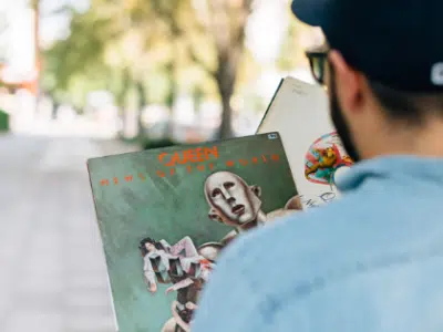 A man wearing a hat holding a book.