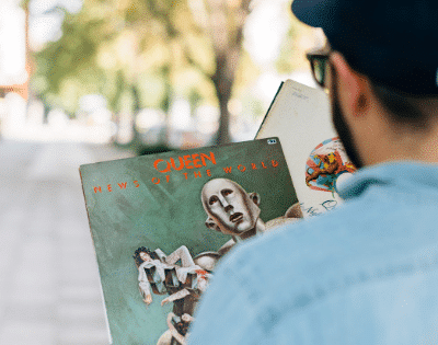 A man wearing a hat holding a book.