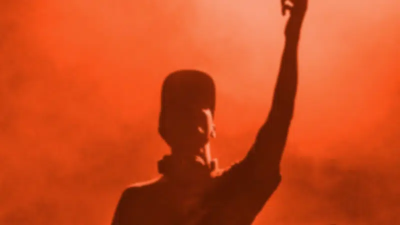 A silhouette of a man with his hands up in the air, representing freedom and expression.