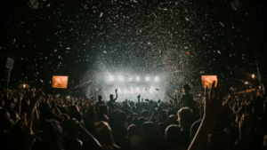 A crowd at a concert with confetti falling from the sky.