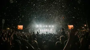 A crowd at a concert with confetti falling from the sky.