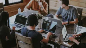 A group of people working on laptops at a table.