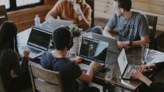 A group of people working on laptops at a table.