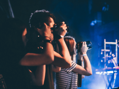 The Most Badass Merch Launch A group of people taking pictures at a concert.
