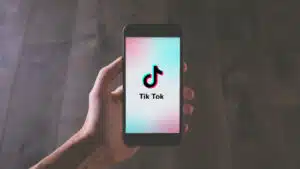 A person holding up a phone with the tikt app on it.