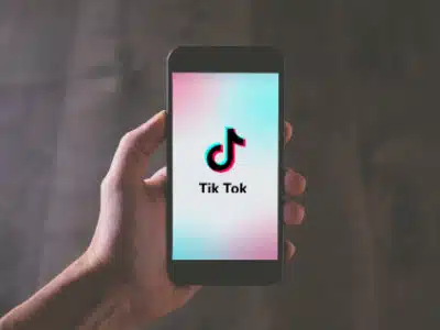 A person holding up a phone with the tikt app on it.