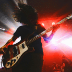 Bassist performing on stage with dynamic lighting in the background for their EPK.
