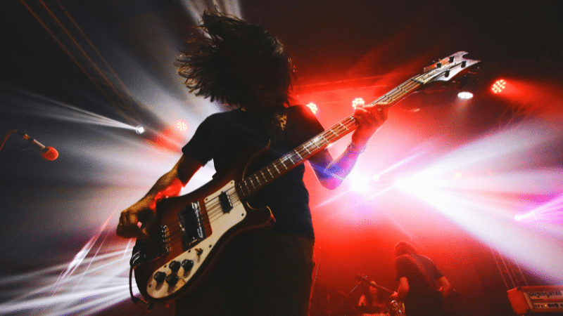 Bassist performing on stage with dynamic lighting in the background for their EPK.