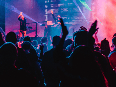 A crowd at a concert with their hands raised.