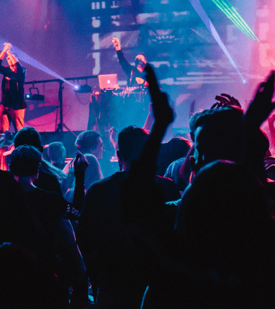 A crowd at a concert with their hands raised.