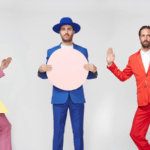 A group of men in colorful suits and hats posing for a picture.