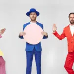 A group of men in colorful suits and hats posing for a picture.