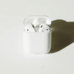 An apple airpods case on a white surface.