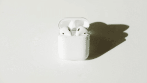 An apple airpods case on a white surface.