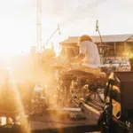 The sun is shining on a stage at an outdoor concert.