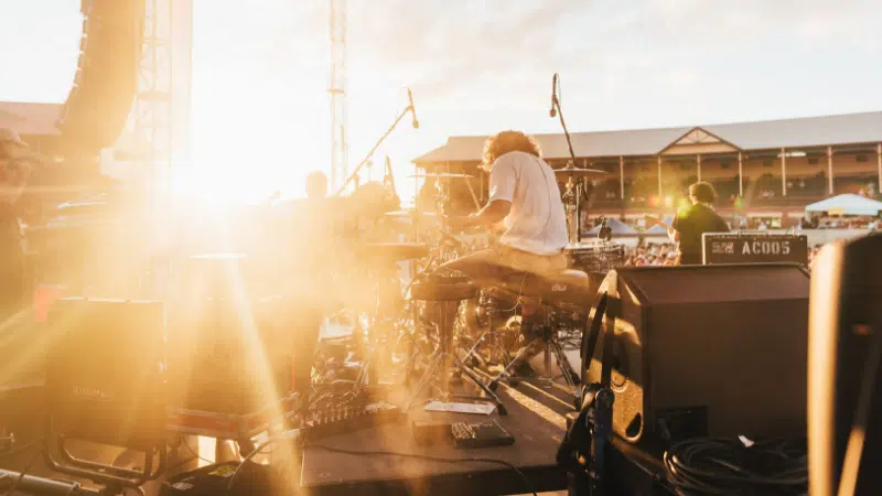 The sun is shining on a stage at an outdoor concert.