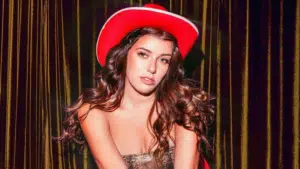 A woman in a red cowboy hat is posing for a photo.