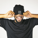 A man wearing a black beanie covering his eyes.