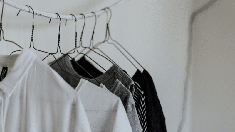 Black and white shirts hanging on a clothes hanger.