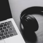 A laptop and headphones on a table.