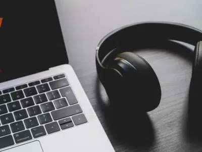 A laptop and headphones on a table.