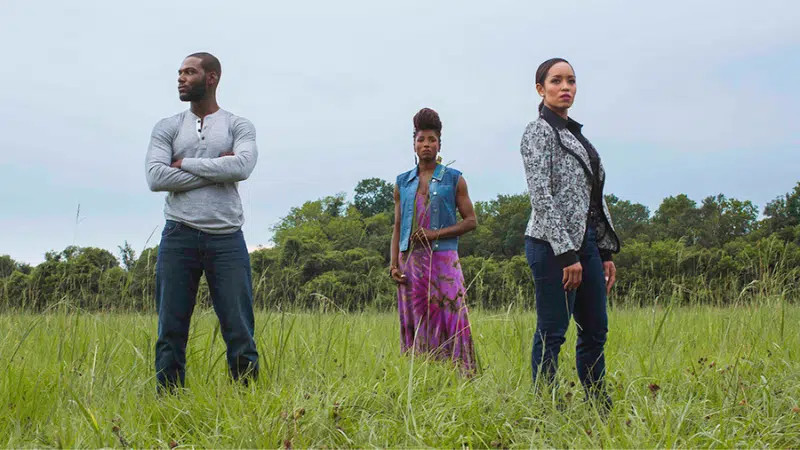 A group of people standing in a field.