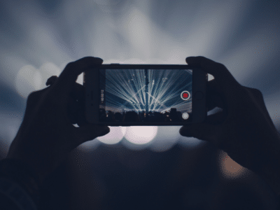 A person is taking a picture of a concert with a cell phone.