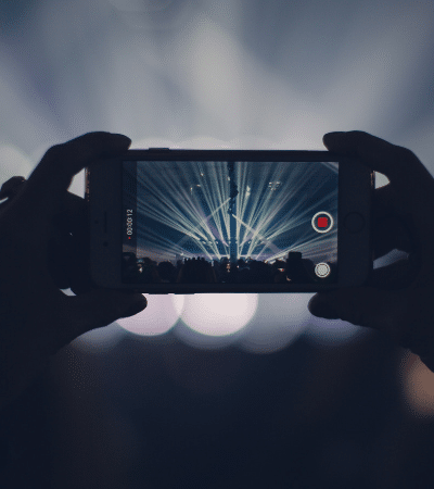 A person is taking a picture of a concert with a cell phone.