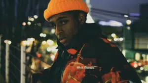 A young man wearing an orange hat and jacket.