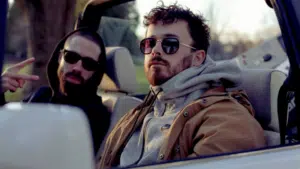 Two men sitting in the back seat of a car.