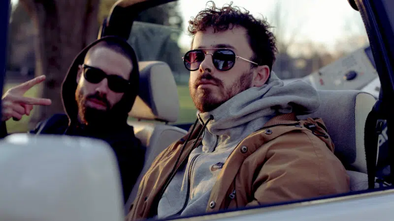 Two men sitting in the back seat of a car.