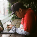 man sitting at computer in coffee shop