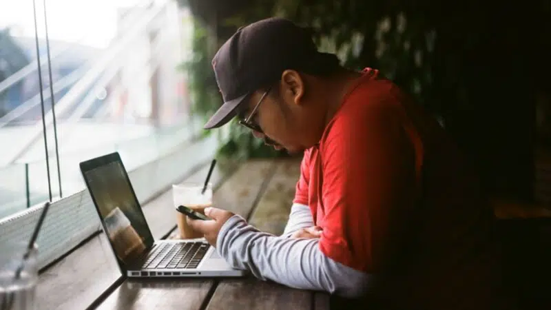 man sitting at computer in coffee shop