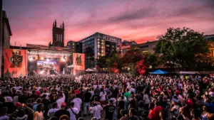 A crowd of people at a music festival at dusk.