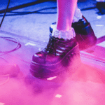 A woman's feet on a stage with a microphone.