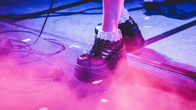 A woman's feet on a stage with a microphone.