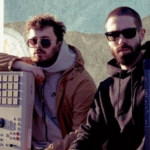 Two men standing next to each other holding electronic keyboards.