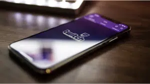 A phone with the twitch logo on it sitting on a table.