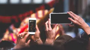 A group of people taking pictures with their cell phones.